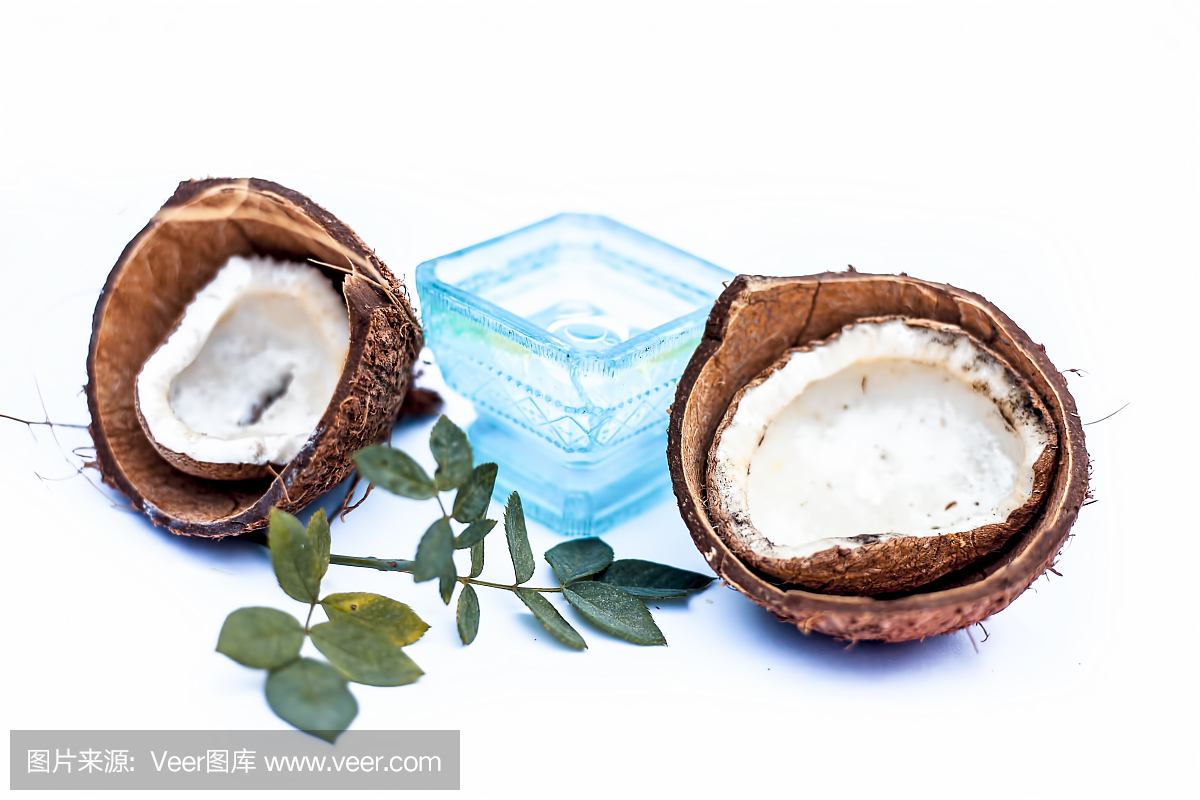 近距離的原料有機椰子油與原料椰子隔離在白色的藍色碗。